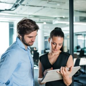 Young businesspeople with tablet in an office, working
